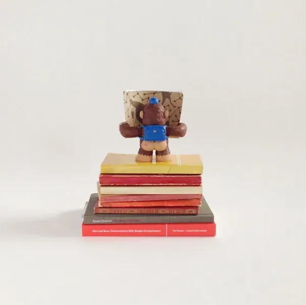 iPhone photo of a vinyl Freddie figure sitting on a stack of books