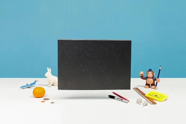 Black laptop silhouette with desk props on blue