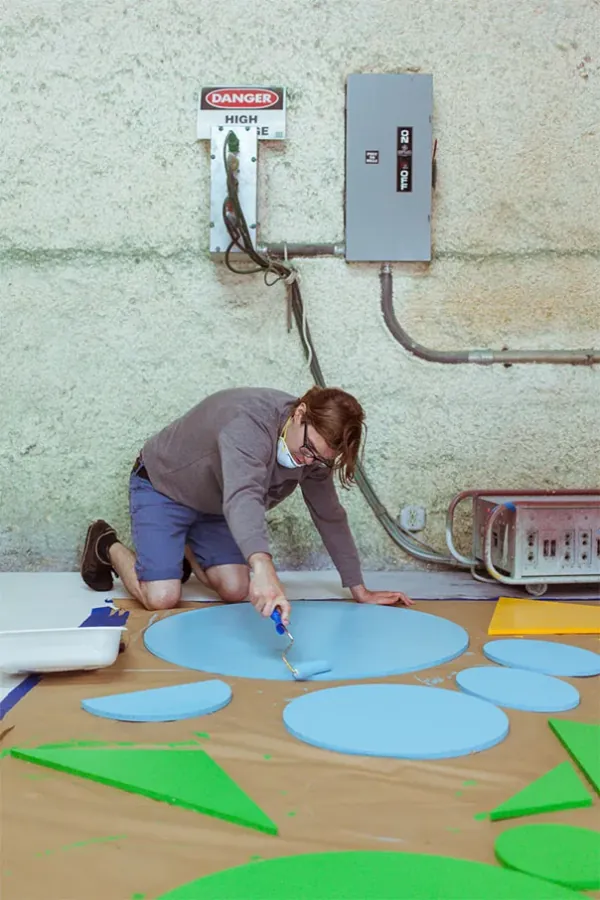 Painting a set floor with blue and green shapes